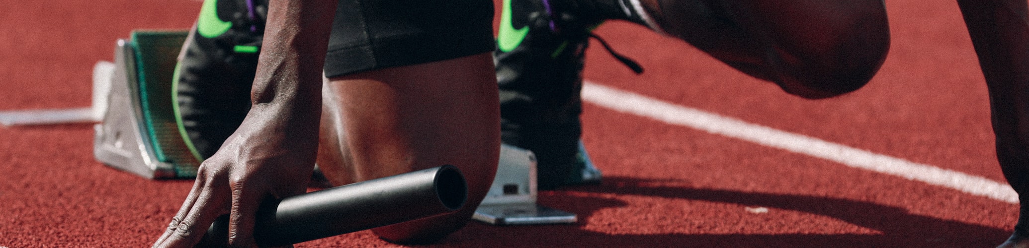 沉浸式体育头图 - 多名运动员在田径赛道上激烈冲刺的瞬间，背景虚化，前景清晰展现肌肉线条与速度感